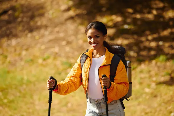 A young African American woman explores a picturesque autumn forest, enjoying the colorful foliage. — Stock Photo