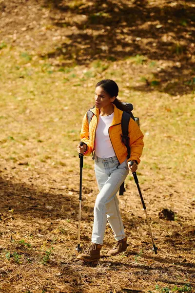A young African American woman navigates a colorful forest trail, immersed in the beauty of autumn. — Stock Photo