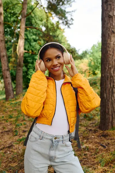 Exploring the lush forest trails, a young woman embraces the autumn colors and adventurous spirit. — Stock Photo