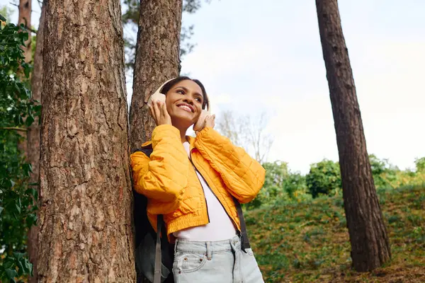 Embracing the beauty of nature, a young woman finds joy while hiking through colorful autumn trees. — Stock Photo