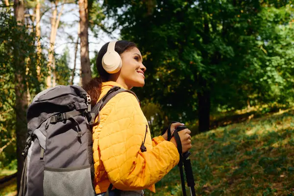 A young African American woman explores a vibrant autumn forest, embracing her adventurous spirit. — Stock Photo