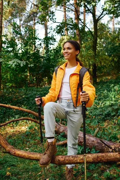 A young African American woman embraces adventure while hiking through a colorful autumn forest. — Stock Photo