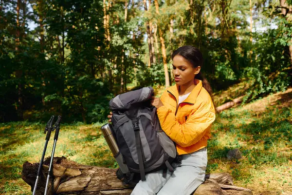A young African American woman explores a colorful forest during autumn, embracing nature beauty and adventure. — Stock Photo