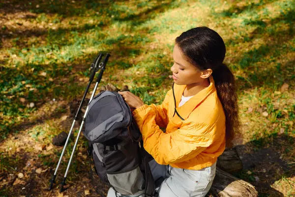 Eine junge Afroamerikanerin genießt ihre Wanderung durch einen bunten Wald, ganz in den Charme der Natur eingetaucht. — Stockfoto