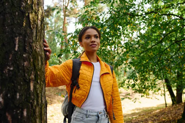 Una joven afroamericana disfruta de una caminata otoñal, rodeada de colorido follaje y aire fresco. — Stock Photo