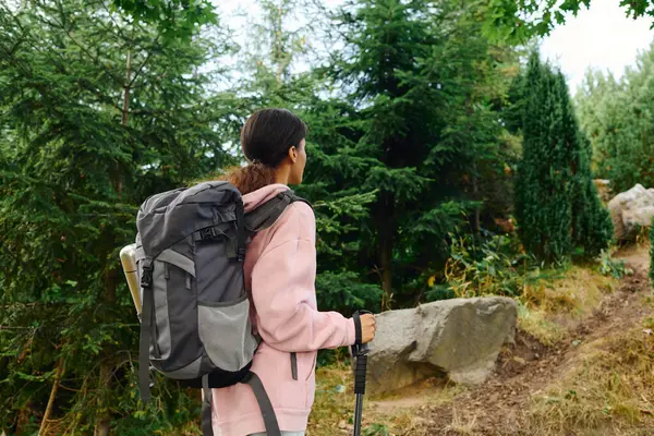 Una joven afroamericana camina por un vibrante bosque otoñal, abrazando la belleza de la naturaleza. - foto de stock