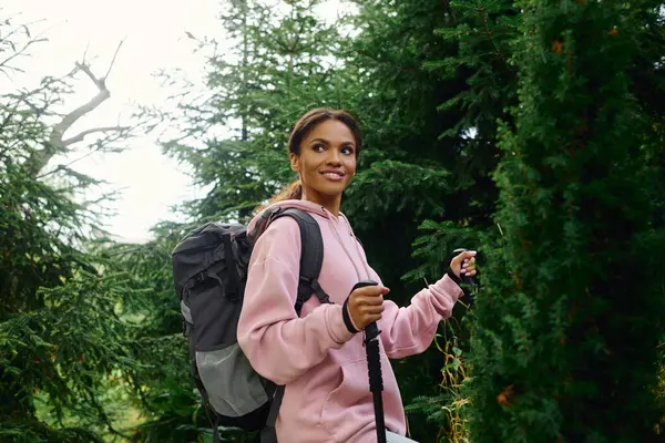 Una giovane donna afroamericana si gode un'avventura escursionistica attraverso una colorata foresta autunnale — Foto stock
