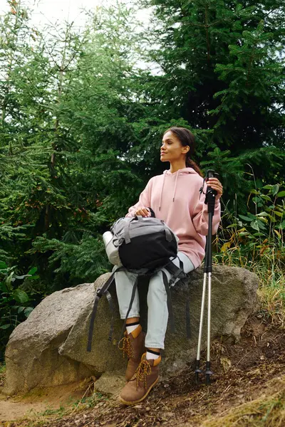 In the heart of autumn, a young woman takes a moment to enjoy nature while hiking in the lush forest. — Stock Photo