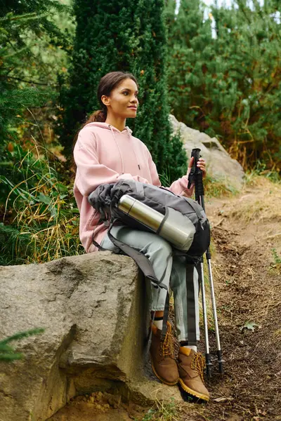A young woman embraces the beauty of autumn as she hikes through a lush forest, soaking in the adventure. — Stock Photo
