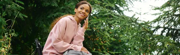 A joyful young woman takes a break while hiking through a vibrant autumn forest surrounded by greenery. — Stock Photo