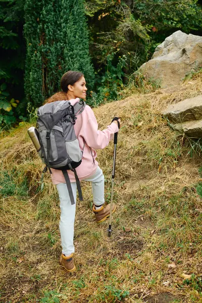 A young African American woman hikes through a colorful autumn forest, embracing nature and adventure. — Stock Photo