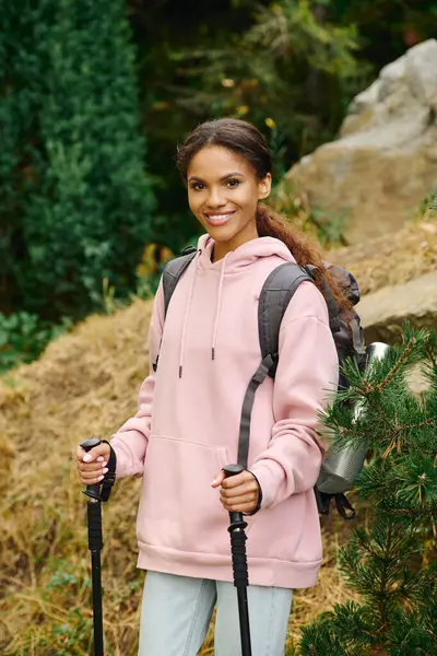 La jeune femme profite d'une randonnée revigorante au milieu du feuillage d'automne coloré, explorant la beauté de la nature. — Photo de stock