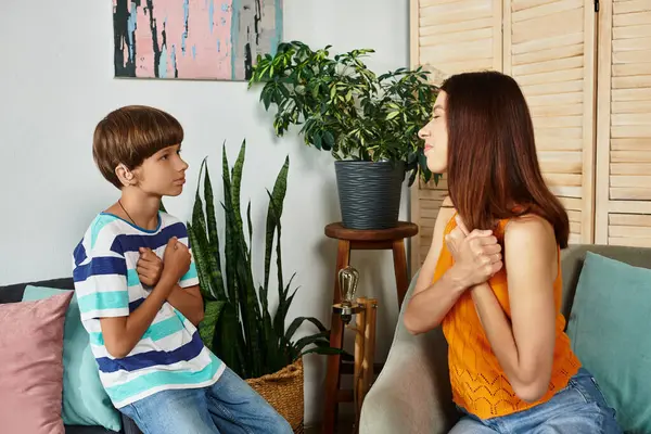 Une mère et son fils sourd partagent une conversation sincère à travers des gestes, renforçant leur lien. — Photo de stock