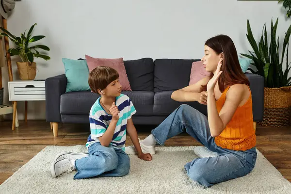In a cozy living room, a mother engages her hearing impaired son in sign language learning. — Stock Photo
