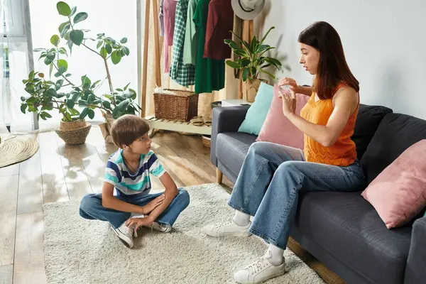 A mother communicates with her son who has hearing impairment, sharing a bonding experience. — Stock Photo
