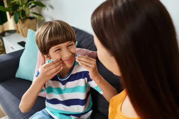 A loving interaction unfolds as a boy with hearing impairment shares a special moment with his mom. — Stock Photo