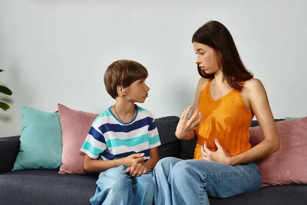 A mother lovingly interacts with her hearing impaired son in a comfortable setting at home. — Stock Photo