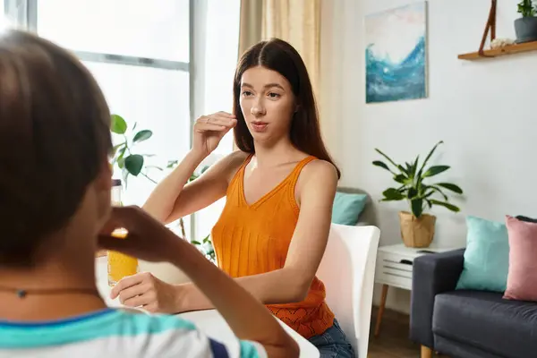 A caring mother engages with her son, using sign language to enhance communication at home. — Stock Photo
