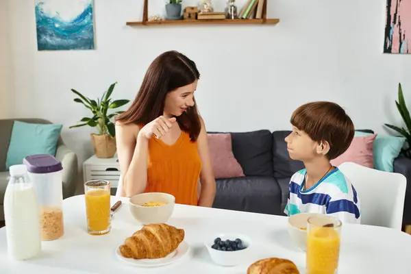 A mother engages with her son, a little boy with hearing impairment, during breakfast together. — Stock Photo