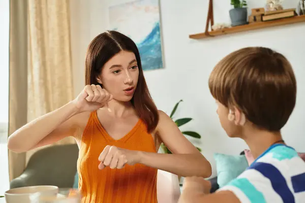 A mother engages her son with hearing impairment in meaningful communication at home. — Stock Photo