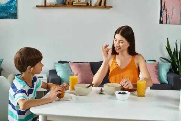 A joyful breakfast shared between a mother and her hearing impaired son, filled with connection. — Stock Photo
