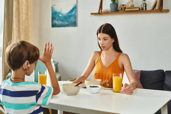A mother engages in a heartfelt discussion with her son at breakfast, fostering connection. — Stock Photo