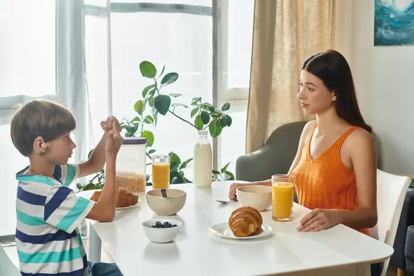 A little boy communicates with his mother over breakfast, filled with warmth and connection. — Stock Photo