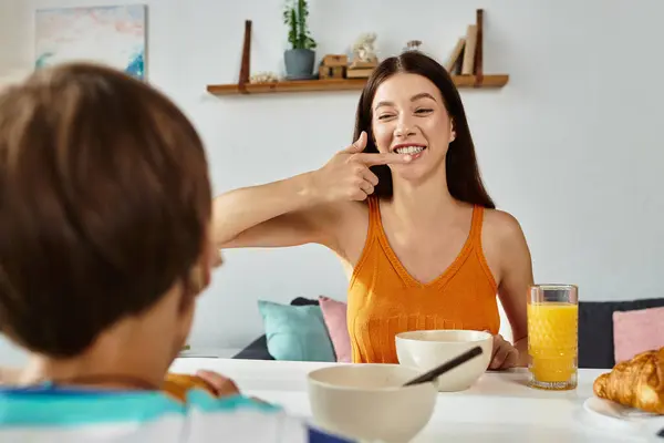 A mother enjoys breakfast with her hearing impaired son, sharing smiles and connection. — Stock Photo