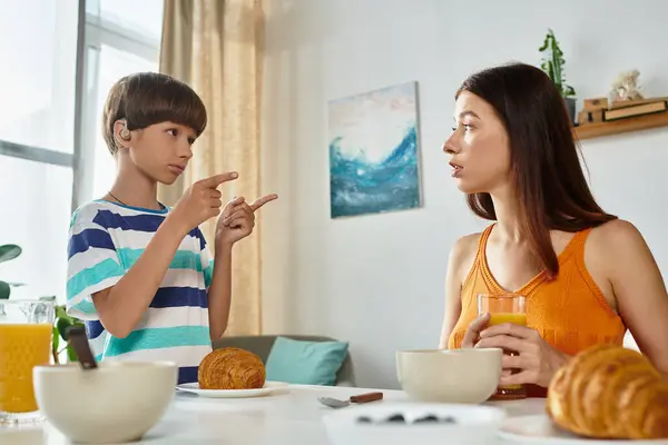 A young boy engages with his mother at the breakfast table, sharing a heartfelt conversation. — Stock Photo