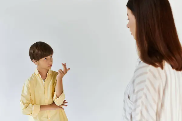 Um menino se comunica através da língua de sinais, expressando seus pensamentos para sua mãe carinhosa. — Fotografia de Stock