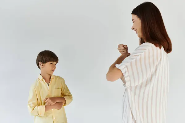 Mãe e filho compartilham uma interação alegre, celebrando seu vínculo e comunicação únicos. — Fotografia de Stock