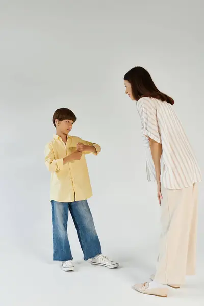 A caring mother engages lovingly with her son who has hearing impairment, promoting connection. — Stock Photo