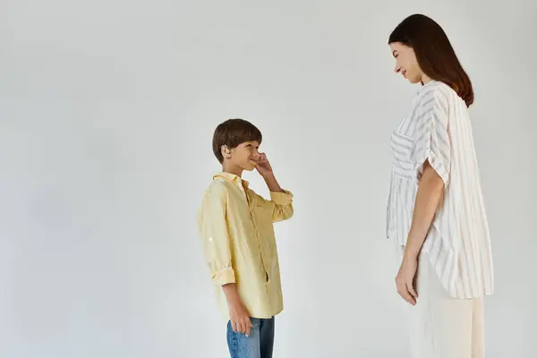 A young boy connects with his mother, who supports him, showcasing their close bond and love. — Stock Photo