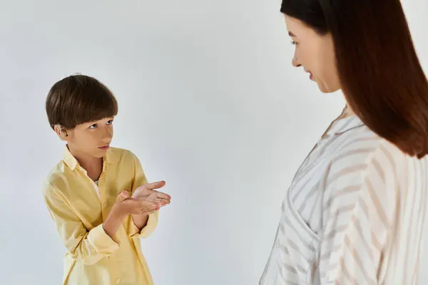 Um menino se comunica com sua mãe amorosa, compartilhando um vínculo especial através de gestos. — Fotografia de Stock