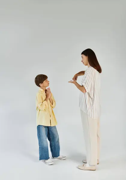 A caring mother engages with her hearing impaired son, fostering communication and connection. — Stock Photo