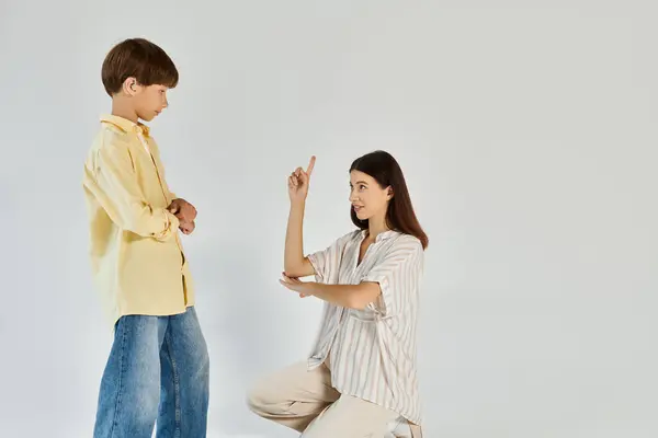 A mother patiently engages her hearing impaired son, fostering understanding and connection. — Stock Photo