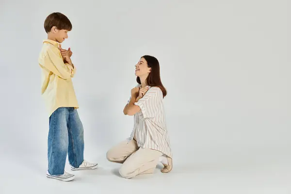 Eine fürsorgliche Mutter kniet nieder, um sich mit ihrem Sohn zu verbinden und fördert so Kommunikation und Liebe. — Stockfoto