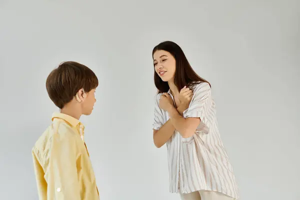 A supportive mother engages her hearing impaired son with warm gestures and smiles at home. — Stock Photo
