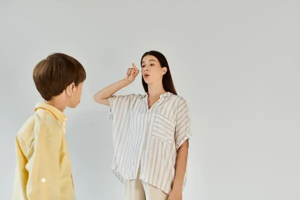 A mother guides her hearing impaired child in learning expression through sign language. — Stock Photo