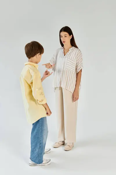 A mother interacts with her son who has hearing impairment, fostering understanding and connection. — Stock Photo