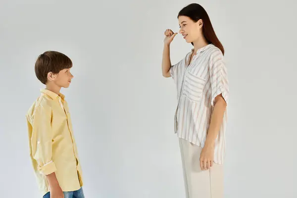 Un niño y su madre comparten un momento de comunicación del lenguaje de señas en un ambiente cálido. — Stock Photo
