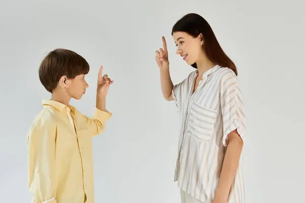 A caring mother guides her son with hearing impairment using meaningful gestures and expressions. — Stock Photo