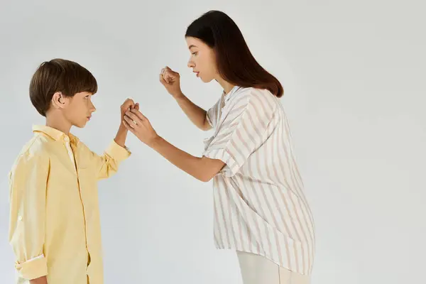 A young boy with hearing impairment learns sign language from his supportive mother. — Stock Photo