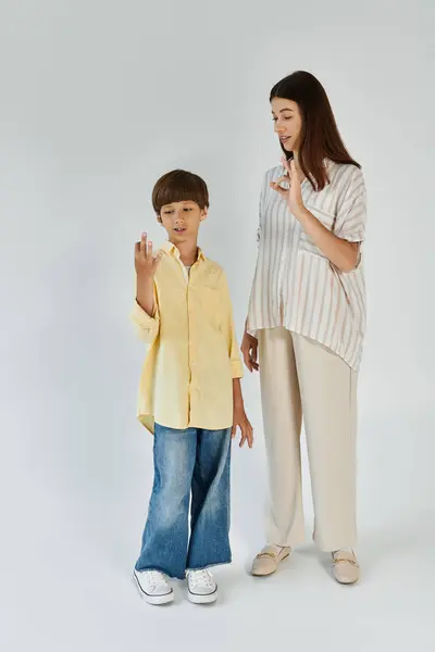 A mother and her son share a tender moment, communicating with sign language together. — Stock Photo