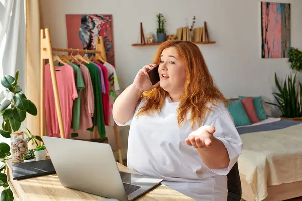 La mujer entabla una animada conversación telefónica mientras está sentada en su escritorio. — Stock Photo