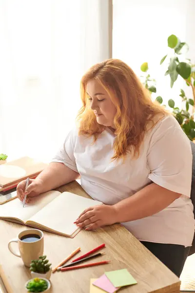 A beautiful plus size woman writes thoughtfully in her journal while enjoying a quiet morning. — Stock Photo