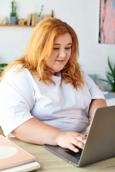 A confident plus size woman is focused on her laptop, deeply engaged in her work at home. — Stock Photo