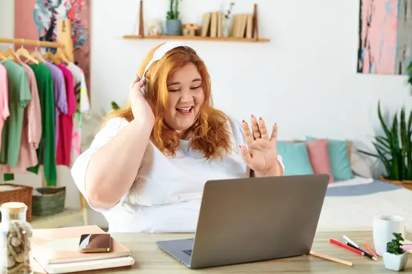 The cheerful woman engages enthusiastically in a video call from her vibrant home office. — Stock Photo