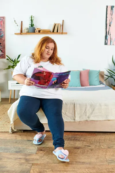 A confident plus size woman stylishly flips through a magazine, enjoying her moment. — Stock Photo