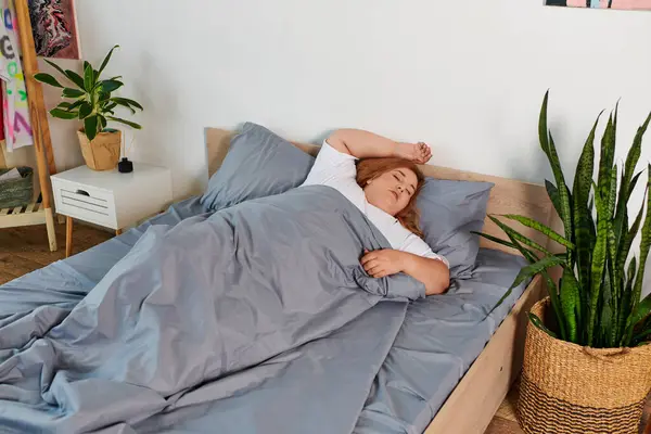 A beautiful plus size woman peacefully rests in her serene bedroom adorned with plants. — Stock Photo